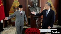 Menteri Pertahanan Prabowo Subianto bersama Menteri Luar Negeri China Wang Yi usai menandatangani buku tamu saat pertemuan di Jakarta, 18 April 2024. (Foto: Achmad Ibrahim/Pool via REUTERS)