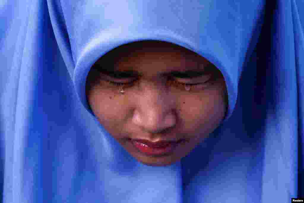 Aisha Rana Zhafirah reacts while visiting the Ulee Lheue mass grave, where victims of the 2004 Indian Ocean tsunami are buried, in Banda Aceh, Aceh, Indonesia.