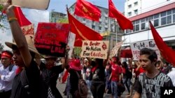 ដោយ​មាន​កាន់​បដា​ជាច្រើន​ ក្រុម​និស្សិត​បាន​ដើរ​កង្ហែ​ក្បួន​ប្រឆាំង​តវ៉ា​ចំពោះ​ច្បាប់​អប់រំ​ជាតិ​កាល​ពី​ថ្ងៃ​ទី​១៧​ ខែ​វិចិ្ឆកា​ ឆ្នាំ​២០១៤​ នៅ​ទីក្រុង​ រ៉ង់ហ្គូន ប្រទេស​មីយ៉ាន់ម៉ា។​ ក្រុម​និស្សិត​រាប់រយ​នាក់​បាន​ដើរ​ដង្ហែ​ក្បួន​នៅ​តាម​បណ្តោយ​ផ្លូវ​នៅ​ក្នុង​ទីក្រុង​Yangon នៅ​ក្នុង​ថ្ងៃទី៤​ជាប់ៗ​គ្នា​ ដោយ​ទាមទារ​ឲ្យ​រដ្ឋាភិបាល​ធ្វើ​វិសោធនកម្ម​ច្បាប់​អប់រំ​ជាតិ​ដែល​ទើប​តែ​ត្រូវ​បាន​អនុម័ត​នា​ពេល​ថ្មីៗ​នេះ ហើយ​ក៏​បាន​ចោទ​ប្រកាន់​ថា​ច្បាប់​ថ្មី​នោះ​បាន​ដាក់​កំហិត​ដល់​សេរីភាព​ក្នុង​ការ​សិក្សា​ និង​ថា​​ច្បាប់​នោះ​មិន​បាន​ឆ្លុះ​បញ្ចាំង​ពី​គំនិត​របស់​និស្សិត​ និង​គ្រូៗ​នោះ​ទេ។ (រូបថត​ដោយ​: AP / Khin Maung Win)