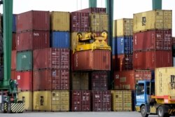FILE - Ship containers are moved at the Port of Sines, in Sines, Portugal, Feb. 12, 2020.