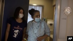 Randa Aweis, right, who received a kidney transplant from Yigal Yehoshua, a Jewish man who died May 17 after clashes between Arabs and Jews in Israel’s mixed city of Lod, walks with her daughter, Nevine at Hadassah Ein Karem Hospital on May 24, 2021. (AP Photo/Maya Alleruzzo)