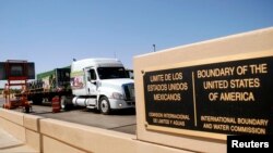 FILE - A truck of the Mexican company Olympics crosses the Puente Internacional Comercio Mundial (World Trade International Bridge) while approaching the border crossing into the U.S., in Laredo.