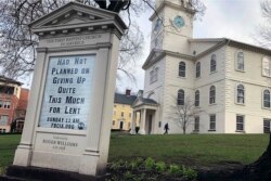 In this March 24, 2020, photo, a man walks past the First Baptist Church in America in Providence, R.I.