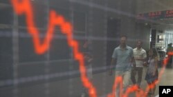People are reflected at an index board inside the Athens stock exchange August 9, 2011.