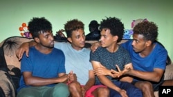 Eritrean under-20 soccer players Hermon Fessehaye Yohannes, Simon Asmelash Mekonen, Hanibal Girmay Tekle, and Mewael Tesfai Yosief talk together in a house where they are staying in Uganda.
