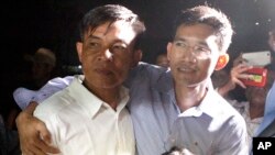 Two former Radio Free Asia reporters Uon Chhin, left, and Yeang Socheamet, right, hold together after they walk outside the main prison of Prey Sar at the outskirt of Phnom Penh, Cambodia, Aug. 21, 2018. 
