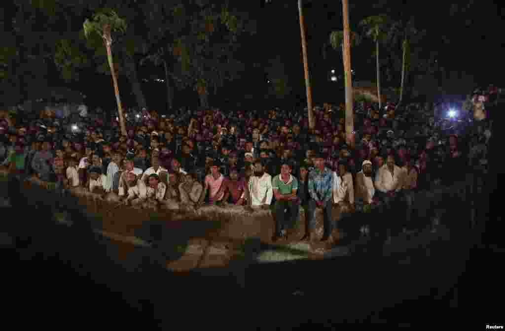 Onlookers watch as rescue workers search for victims after a residential building collapsed on the outskirts of Mumbai, India, April 4, 2013. 