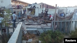 Ljudi proveravaju štetu nastalu kada je raketa pogodila kamp za raseljene ljude, tokom borbi između rivalskih naoružanih grupa, u Tripoliju, Libija, 2. septebra 2018.