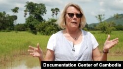 លោកស្រី Elizabeth Becker ឈរ​ជាមួយ​លោក ឆាំង យុ និង​គណៈប្រតិភូ​មួយ​ឈរ​នៅ​ក្បែរ​រណ្ដៅ​​គ្រាប់​បែក​ B52 នៅ​ជិត​អាកាសយានដ្ឋាន​សាងសង់​ដោយ​ចិន នៅ​ខេត្ត​កំពង់ឆ្នាំងកាល​ពី​ថ្ងៃ​ទី​២៤ ខែ​តុលា ឆ្នាំ​២០១២។ (រូបថត​ដោយ ញាណ សុជាតិ/មជ្ឈមណ្ឌល​ឯកសារ​កម្ពុជា) 