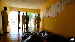 Des membres de la famille attendent de recevoir des corps de victimes d'attentats suicides dans un hôpital de Konduga, à l'extérieur de Maiduguri, au Nigeria, le 16 août 2017.