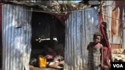 A child stands in front of a makeshift home in the Ma Drapo camp. (Matiado Vilme/VOA Creole) 