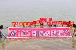 Protesters participate in a mock drowning as a signal to the world that they, as their country, need to be saved, in Nyaung-U, Myanmar, March 19, 2021.
