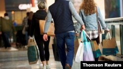 FILE PHOTO: Shoppers carry bags of purchased merchandise at the King of Prussia Mall, United States' largest retail shopping space, in King of Prussia
