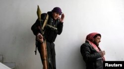 A fighter from the Sadik unit of Free Syrian Army's Tahrir al Sham brigade reacts as a missile fired by Syrian air force jet explodes near by during heavy fighting in Mleha suburb of Damascus, Jan. 22, 2013. 
