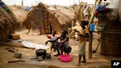 FILE - Families prepare food in a refugee camp in Kaga-Bandoro, Central African Republic, Feb. 16, 2016. Ex-Seleka fighters attacked a refugee camp there Oct. 12. 