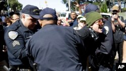 San Francisco Police Officers arrest a protester outside of Alamo Square Park in San Francisco, Aug. 26, 2017. 