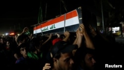 Men carry the coffin of a demonstrator who was killed during anti-government protests, in Baghdad, Iraq, Oct. 4, 2019. 