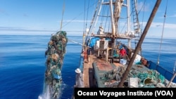 Ocean Voyages Institute in Sausalito, California works to clean up trash in the ocean. Here, tons of garbage – much of it plastic -- from the Great Pacific Garbage Patch is being lifted onto a cargo sailing ship. The debris is recycled or turned into fu