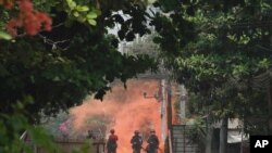 30일 미얀마 양곤에서 군인들이 군부 쿠데타 반대 시위대를 향해 전진하고 있다.