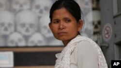 រូប​ឯកសារ៖ ស្ត្រី​ម្នាក់​​ឈរ​នៅ​មុខ​ចេត្តិយ​ដែល​ត​ម្កល់​លលាដ៍​​និង​ឆ្អឹង​​របស់​ជន​រង​គ្រោះ​​​ក្នុង​របប​​ខ្មែរ​ក្រហម​​នៅ​សារមន្ទីរ​ជើង​ឯក​នៅ​ជាយ​រាជធានី​ភ្នំពេញ កាល​ពី​ថ្ងៃ​សុក្រ​ទី​១៧ ខែ​មេសា ឆ្នាំ​២០១៥។ 