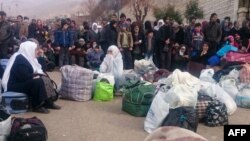Syrians wait for the arrival of an aid convoy on Jan. 11, 2016 in the besieged town of Madaya as part of a landmark six-month deal reached in September for an end to hostilities in those areas in exchange for humanitarian assistance.