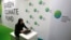 A woman works her computer at the Green Climate Fund stand at the COP21, United Nations Climate Change Conference, in Le Bourget, north of Paris, Nov. 30, 2015.