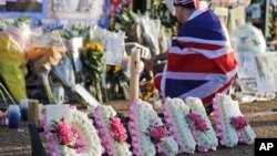 A royal fan for the late Diana, Princess of Wales, stands outside Kensington Palace to pay tribute to her in London, Aug. 31, 2017.