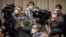 Journalists wearing face masks attend an official press conference about a virus outbreak at the State Council Information Office in Beijing, Jan. 26, 2020. 