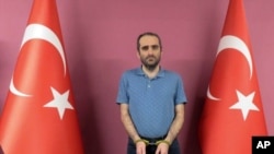 Selahattin Gulen, a nephew of U.S.-based Muslim cleric Fethullah Gulen, stands between Turkish flags in this photo provided by Turkish intelligence service, May 31, 2021, in Ankara, Turkey.