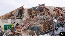 Watu wakitafuta miili katika eneo la mlipuko huko Mogadishu, Somalia Alhamisi, Novemba 25, 2021.AP