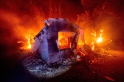 Flames from the LNU Lightning Complex fires consume a home in unincorporated Napa County, Calif., Aug. 19, 2020.