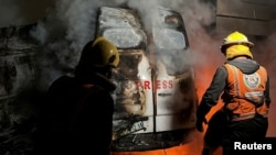 เจ้าหน้าที่ดับไฟบริเวณรถถ่ายทอดสด หลังการโจมตีทางอากาศที่คร่าชีวิตผู้สื่อข่าว 5 คน จากสื่อ Al-Quds Al-Youm TV อ้างอิงจากหน่วยงานสาธารณสุขกาซ่า ในนูเซรัต ทางตอนกลางกาซ่า 26 ธ.ค. 2024 (REUTERS/Khamis Said)