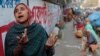 FILE - Anwara, 55, a Bangladeshi daily wage laborer who earns less than $4 per day, laments the lack of work due to the political unrest as she awaits work by a roadside during the second day of a 72 hours long strike called by the opposition Bangladesh National Party.