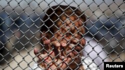 A Mexican migrant talks to a family member through the border fence between Ciudad Juarez and El Paso, United States, after a bi-national Mass in support of migrants in Ciudad Juarez, Mexico, Feb.15, 2016. (REUTERS/Jose Luis Gonzalez)