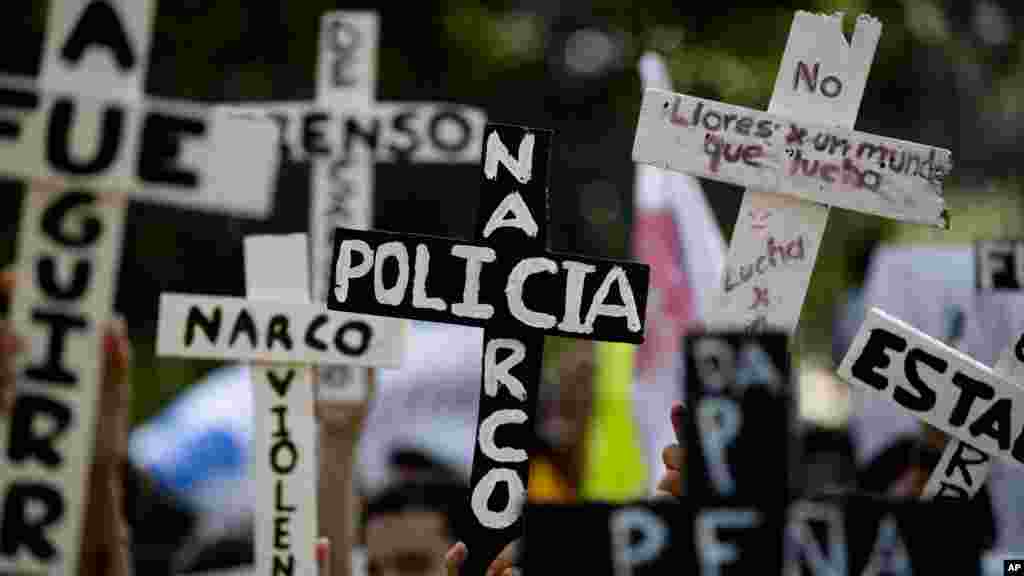 Demonstrators march with crosses with writing that reads in Spanish "Narco Cops" in protest for the disappearance of 43 students in the state of Guerrero, in Mexico City, Nov. 5, 2014.
