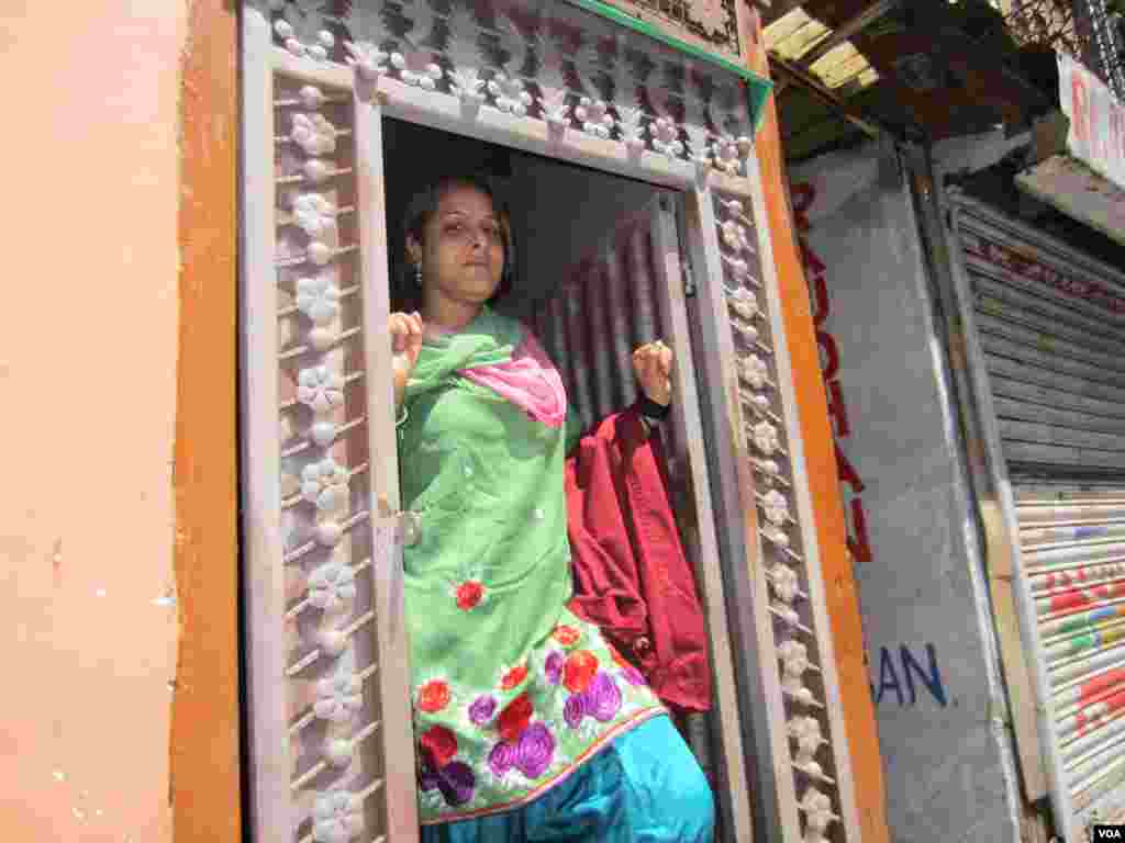 A Kashmiri woman looks out her doorstep in Srinagar. (Aru Pande/VOA) 