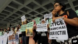 FILE - A migrant workers alliance group holds placards to protest the killings of two Indonesian women in 2014, outside the High Court in Hong Kong, Oct. 24, 2016. 
