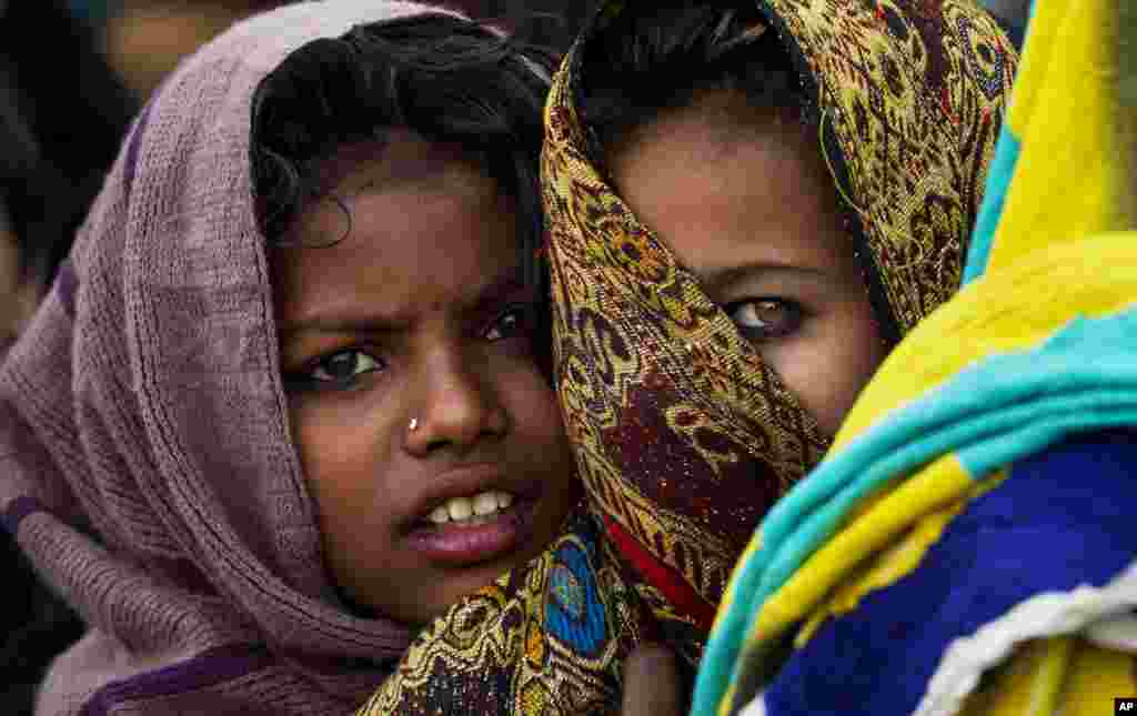Pakistani girls wait in line to receive free food during a rally marking the birthday of Islam&#39;s Prophet Muhammad, in Rawalpindi.