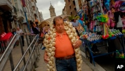 A man carries a strip of garlic during the garlic fair in Vitoria, northern Spain, July 2016. (AP Photo/Alvaro Barrientos)
