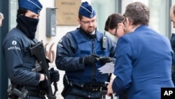 Polisi memeriksa identitas orang-orang yang akan memasuki gedung pemerintah di Brussels, Belgia (16/1). (AP/Geert Vanden Wijngaert)