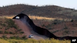 FILE - U.S. Border Patrol agents patrol the border fence in Naco, Arizonia, Oct. 2, 2012.