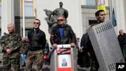 Para anggota kelompok sayap kanan ultra nasionalis Right Sector, berdiri di depan gedung parlemen di Kiev, Ukraina, 28 Maret 2014 (Foto: dok/ AP Photo/Sergei Chuzavkov).