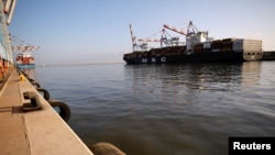 FILE - A cargo ship docks as its cargo is unloaded at Haifa's port, northern Israel, Oct. 12, 2020.