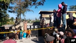 FILE - People stand outside the Orphanage of the Church of Bible Understanding outside Port-au-Prince, Haiti, on Feb. 14, 2020. A fire broke out at the children's home the previous night. 