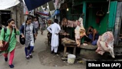 People walk past a shop selling cow meat in Kolkata, capital of the eastern Indian state of West Bengal.