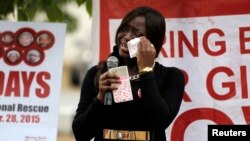 FILE - A member of the protest group wipes away tears during a daily sit-in of the #BringBackOurGirls protest marking the eve of the first anniversary of the killing of 59 students of the Bunu Yadi Federal Government College in Yobe State by Boko Haram, i