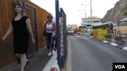 Dua warga melewati terminal Taba di kawasan Semenanjung Sinai Mesir, dekat kota perbatasan Eilat, Israel (18/8).