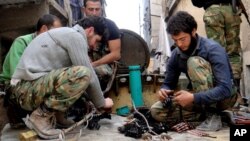 Citizen journalism image provided by Aleppo Media Center AMC which has been authenticated based on its contents and other AP reporting, shows members of the free Syrian Army preparing their weapons, April 25, 2013.