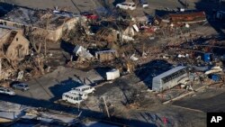 In a view from this aerial photo, people walk amidst destruction from a recent tornado in downtown Mayfield, Ky., Sunday, Dec. 12, 2021. (AP Photo/Gerald Herbert)