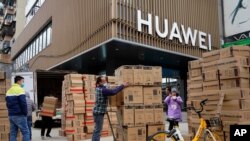 16일 중국 허베이성 우한의 화웨이 매장 앞에서 직원들이 컴퓨터를 옮기고 있다.